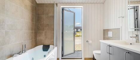 Un bagno moderno con vasca, water e lavabo.