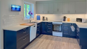 A modern kitchen with grey cabinets, a dishwasher, an oven, and a microwave. - Cozy home in Bolmsö with sauna (Bolmsö)