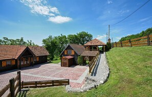 A rustic lodge with multiple wooden cabins, a central building with a red-tiled roof, and a gravel courtyard. - Beautiful home in Radoboj (Radoboj)