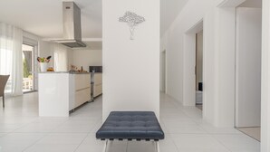 Una cocina moderna con una isla central, un banco al frente y un adhesivo de árbol en la pared.