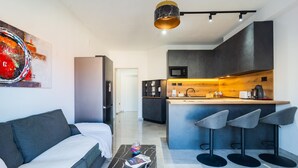 A modern living room with a sofa, a coffee table, and a painting on the wall. - 1 bedroom stunning apartment in Hvar (Hvar)