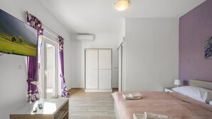 A modern hotel room with a bed, a TV, a desk, and a wardrobe. - Gorgeous apartment in Pirovac with WiFi (Pirovac)