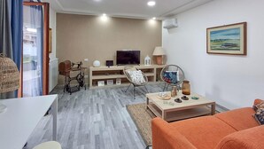 A modern living room with a sofa, a television, a sewing machine, and a dining table. - Beautiful home in Nettuno with WiFi (Nettuno)