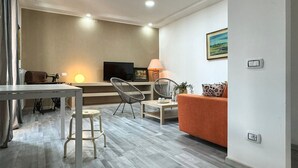 A modern living room with a sofa, chairs, a TV, a lamp, and a sewing machine. - Beautiful home in Nettuno with WiFi (Nettuno)