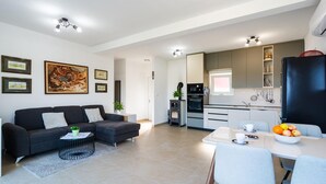 A modern apartment with a living room, dining area, and kitchen.