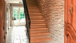 Una escalera con un muro de piedra a un lado y una puerta de madera al otro.