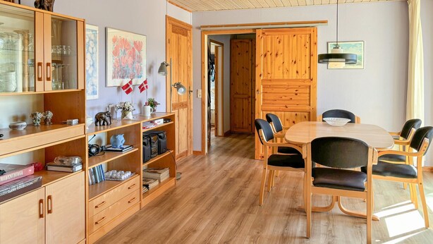 A cozy room with wooden furniture, a dining table, and shelves with various items. - Stunning home in Farsø with WiFi (Farsø)