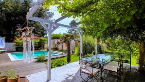A backyard with a pool, a pergola, and a table with chairs. - Beautiful home in Grospierres (Grospierres)