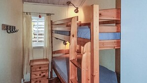 A bunk bed room with a wooden floor, a small wooden dresser, and a window with blinds. - Nice apartment in Sälen with sauna (Sälen)