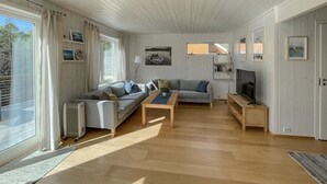 A spacious living room with a sofa, a coffee table, and a television.