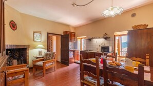 A cozy living room with a fireplace, a dining area with wooden furniture, and a kitchen with modern appliances. - Pet friendly apartment (Monte S.Maria Tiberina)