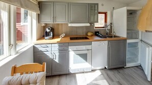 A compact kitchen with grey cabinets, a wooden countertop, a sink, a dishwasher, and a window. - Beautiful home in Höör with WiFi (Höör)