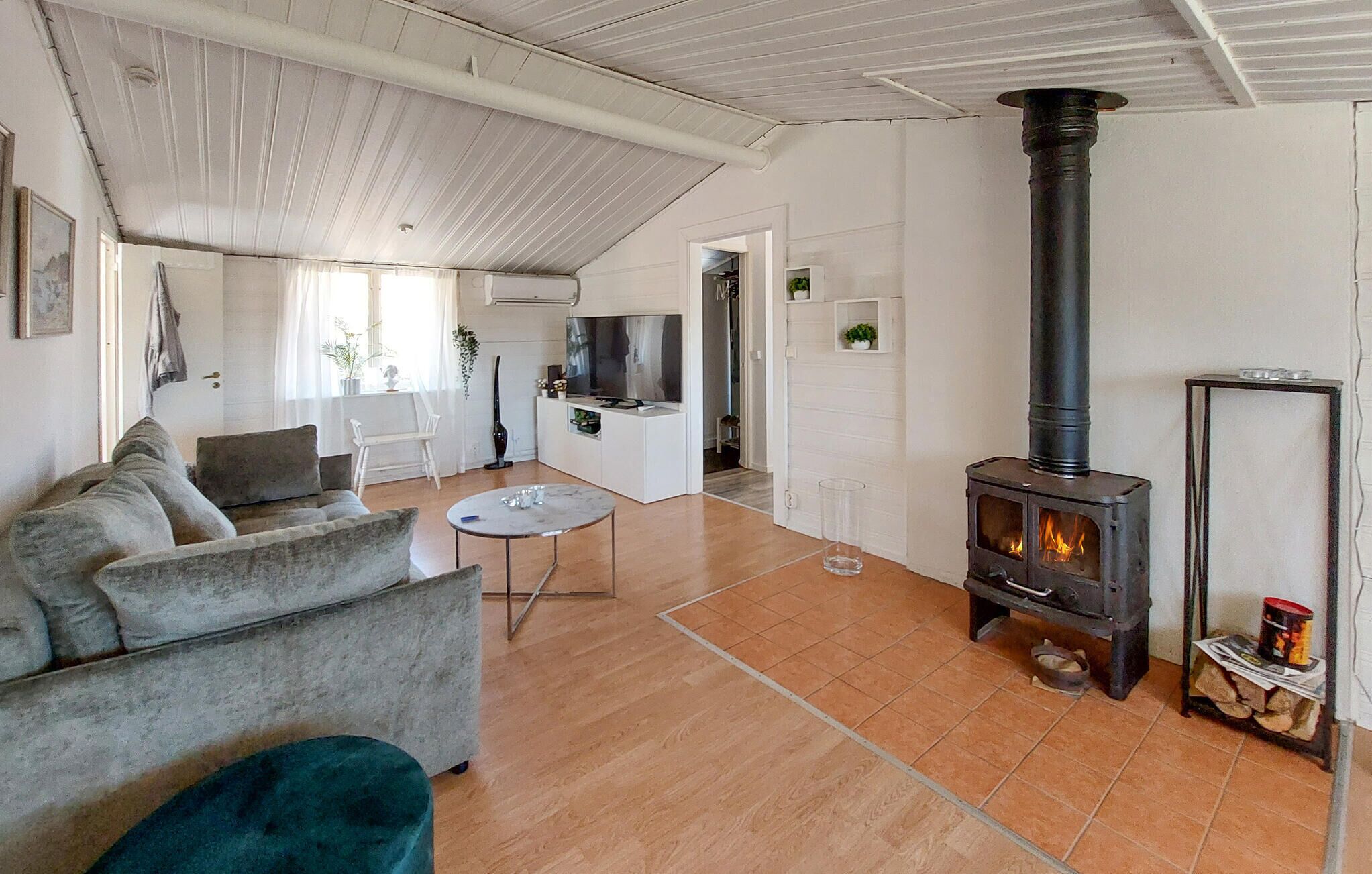 Ein Wohnzimmer mit einer Couch, einem Couchtisch, einem Fernseher und einem Kamin.