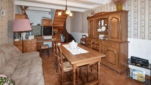 Una sala de estar acogedora con un sofá y un comedor con una mesa y sillas de madera.
