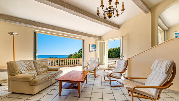 A spacious balcony with a view of the sea, furnished with a sofa, chairs, and a wooden table. - Gorgeous home in Saint Aygulf (Saint Aygulf)