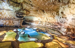 Eine Höhle mit natürlichen Felsformationen und einem Wasserbecken.