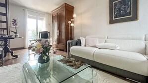 A living room with a glass coffee table, a white sofa, and a wooden cabinet. - Gorgeous home in Roquemaure (Roquemaure)