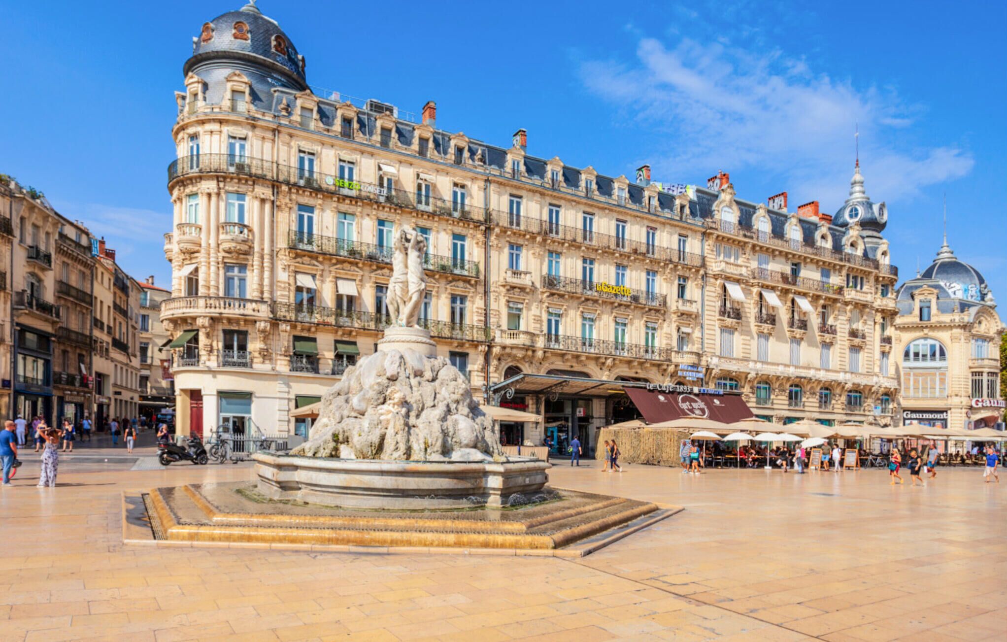 A historic building with a central fountain, multiple balconies, and a dome structure.