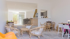Un espace intérieur spacieux, aménagé avec des meubles en osier, une table à manger et un coin bar.