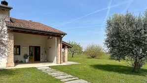 A house with a tiled roof, a stone pathway leading to the entrance, and a well-maintained lawn. - Cozy home in Rosà with WiFi (Rosà)
