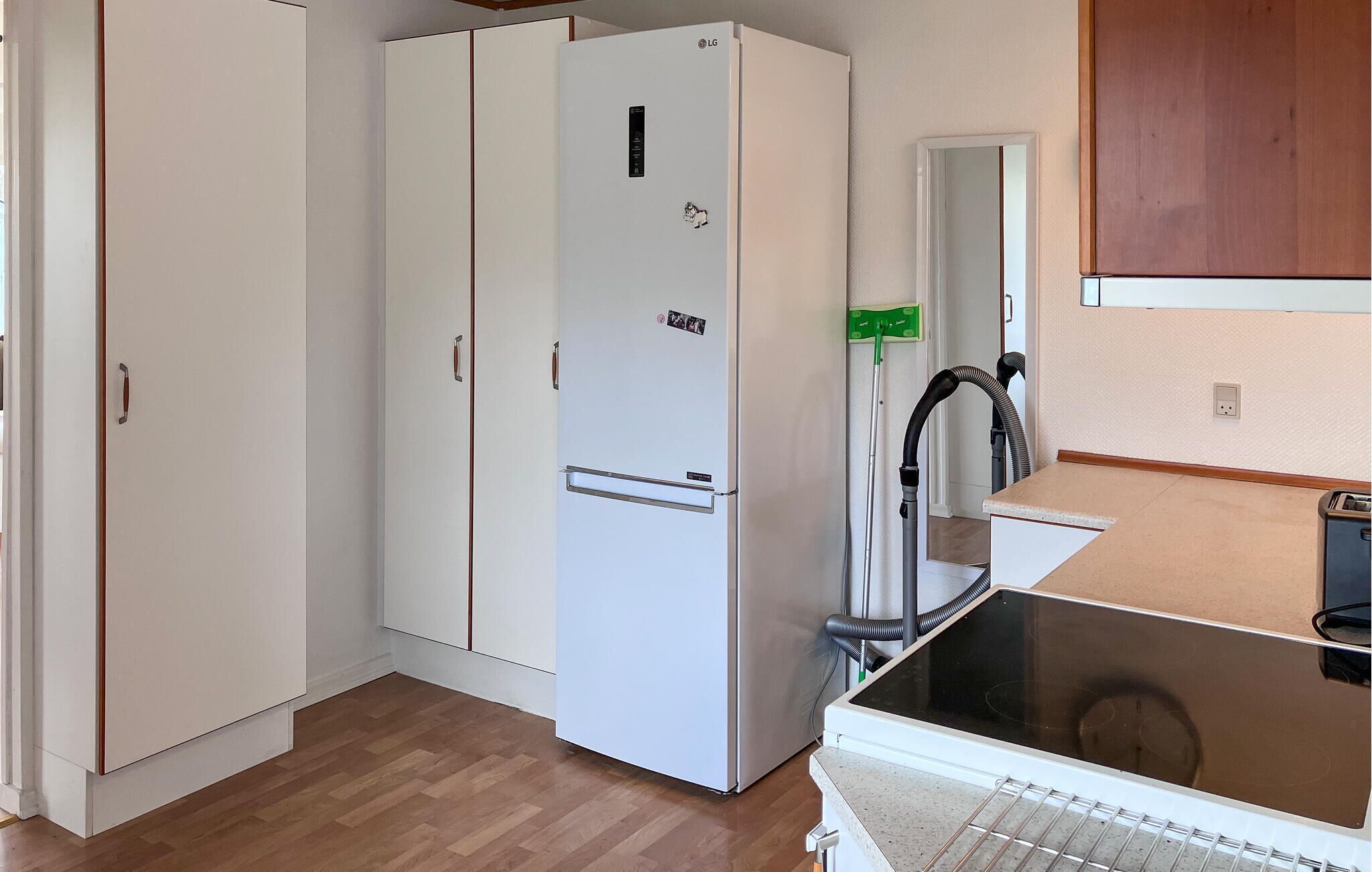 A compact kitchen with a white refrigerator, a microwave, and a sink.
