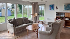 A modern living room with a sofa, armchairs, a coffee table, and a bookshelf. - Lovely home in Kirke Hyllinge (Kirke Hyllinge)