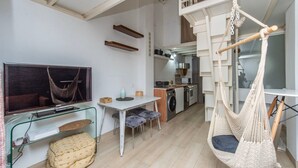 A compact living space with a TV, dining area, kitchen, and a hammock. - GuestReady - Confy Flat in Madrid (Madrid)