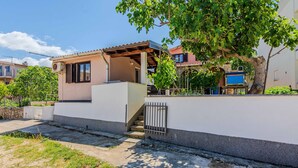 A residential property with a covered patio, a staircase leading to a second floor, and a white wall with a metal gate. - Beautiful apartment in Vir with WiFi (Vir)