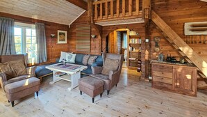 A cozy log cabin interior with a sofa set, a coffee table, and a wooden chest of drawers. - Stunning home in Flesberg with sauna (Flesberg)