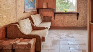 A room with a wooden wall, a map, a window with a view of trees, and a sofa. - Cozy home in Plock with house a panoramic view (Plock)