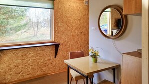 A small room with a window, a round mirror, a table, and a chair. - Cozy home in Plock with house a panoramic view (Plock)