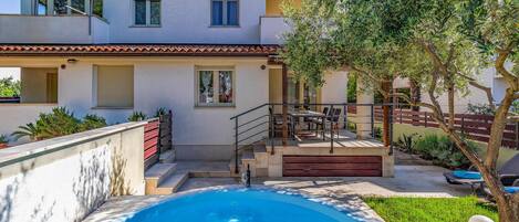 Enjoy a refreshing swim in the pool surrounded by a tranquil outdoor space with a balcony and patio area.