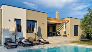 A modern house with a swimming pool, outdoor seating, and a covered patio area. - Lovely home in Galizana (Galizana)