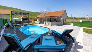 A swimming pool with lounge chairs and a barbecue area. - Gorgeous home in Kricke (Kricke)