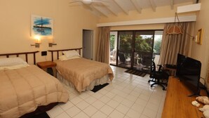 Una camera d'albergo con due letti, una ventola a soffitto, una TV e un balcone con mobili da esterno.
