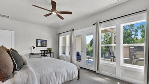 A bedroom with a large bed, a ceiling fan, and a sliding glass door leading to an outdoor patio. - Hillside Harmony Luxury Comfort (Boise)