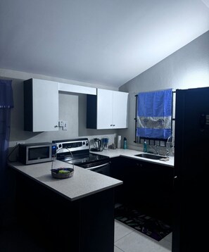 Private kitchen - Ts Staycation - a charming 2-bedroom house with WiFi, AC in Spanish Town (Spanish Town)