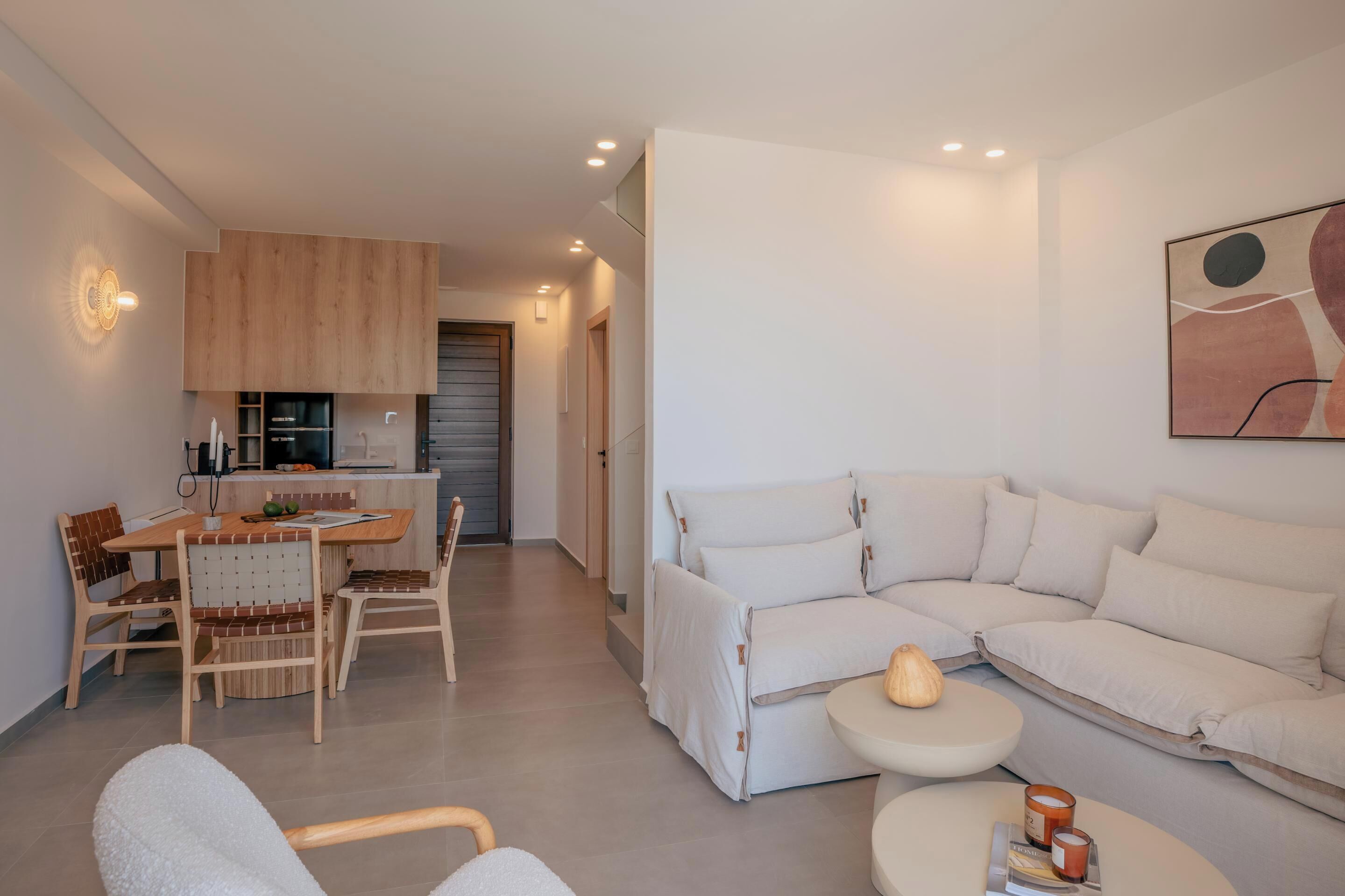 Un salon moderne avec un canapé, une table à manger et des chaises, et un coin cuisine en arrière-plan.