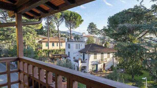 A balcony with a wooden railing overlooking a residential area with houses and trees. - IL CASTELLETTO (Grottaferrata)