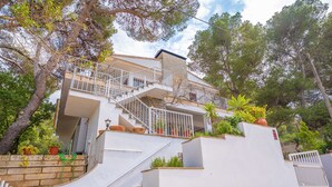 A multi-story house with a white exterior, a staircase leading to the upper floor, and potted plants on the roof. - Ca n Quiros in Mallorca (Santa Margalida)