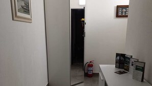 A hallway with a white door, a fire extinguisher, and a counter with brochures. - casa homie (Lavagna)