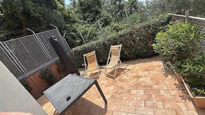 A patio with a brick floor, two chairs, a table, and a metal fence. - casa homie (Lavagna)
