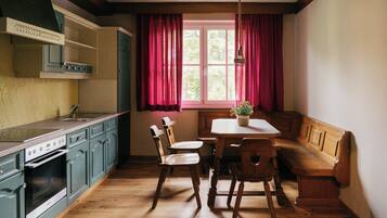 A kitchen with wooden cabinets, a dining table, and a bench.