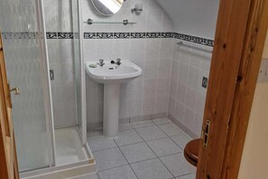 Une salle de bain avec une douche, un lavabo et des toilettes.