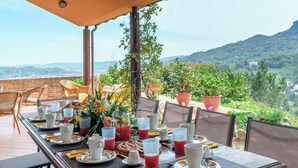 A dining table set for breakfast with a scenic mountain view in the background. - Villa Lia 10, Emma Villas (Roccafluvione)