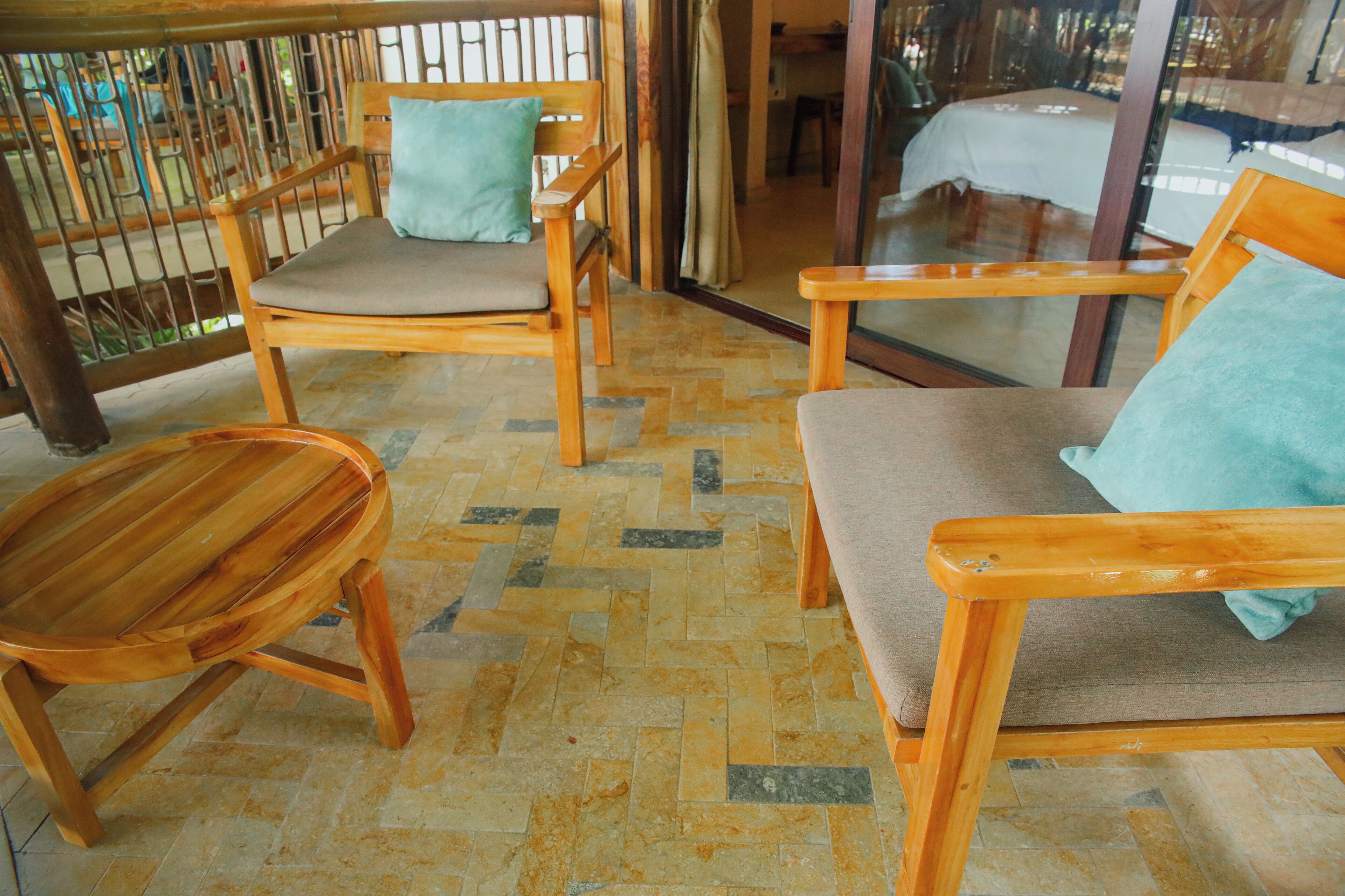A room with wooden furniture, including chairs and a table, and a tiled floor.