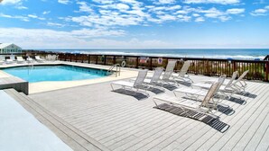 A poolside area with lounge chairs and a view of the ocean. - Perdido Skye #24 by Southern Vacation Rentals (Pensacola)