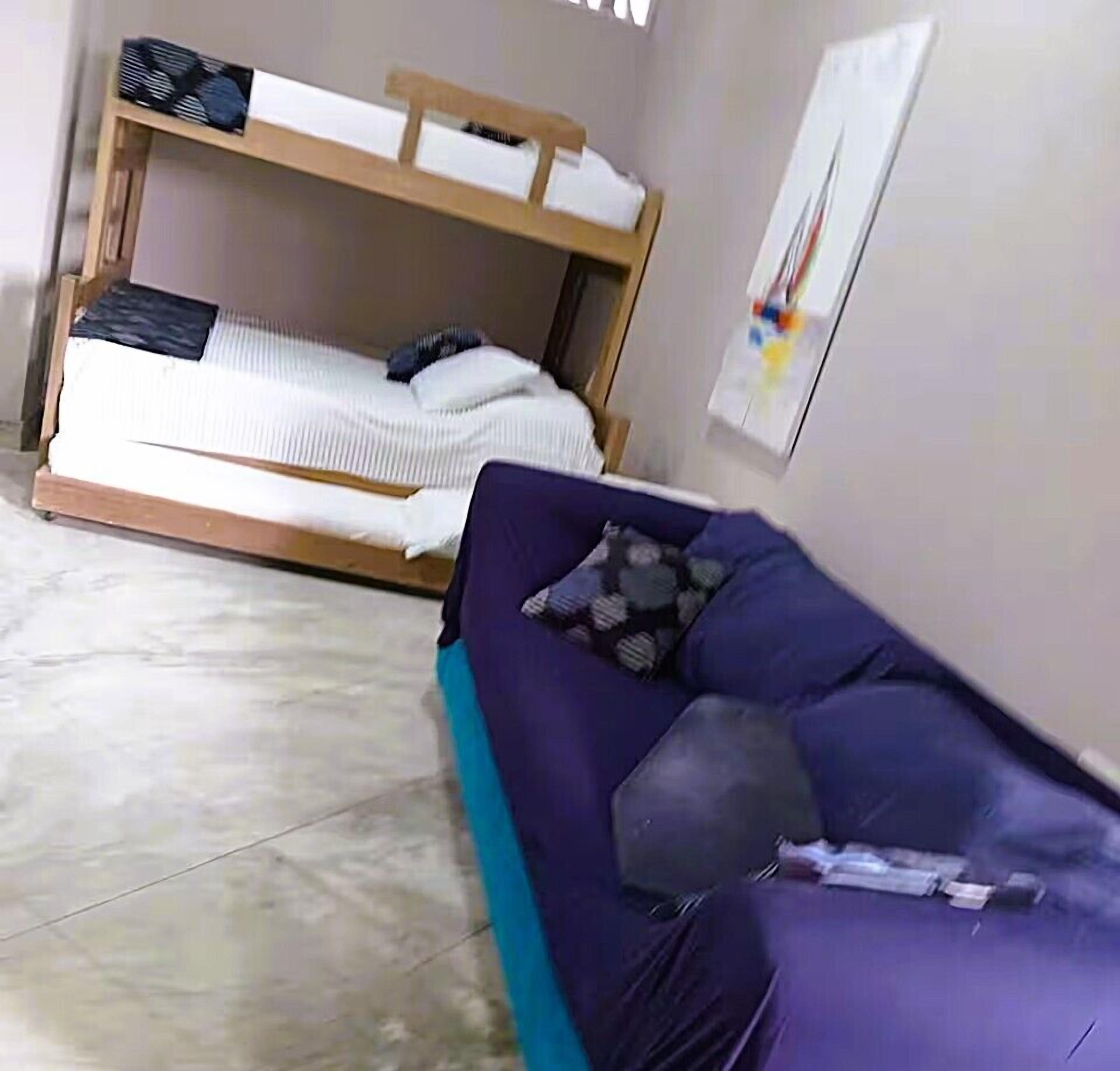 A room with a bunk bed and a sofa.