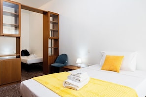 Ett hotellrum med en säng, en stol, ett skrivbord och en garderob.