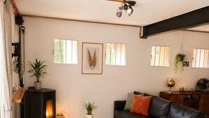 A living room with a sofa, armchair, and a fireplace. There are windows, a plant, and a globe on a table. - Loft with Pool near Valencia and the Ricardo Tormo Circuit (VC)